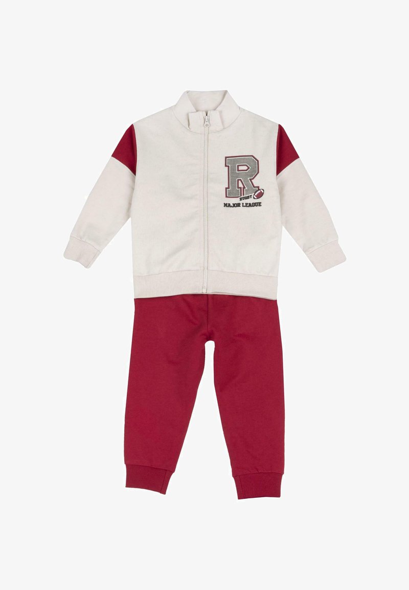 Czerwony i kremowy dres rozpinany wykonany z miękkiego materiału. Posiada ribbowe mankiety, pionowe paski na rękawach i nadrukowane logo na klatce piersiowej.