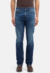 Męskie niebieskie dżinsy w średnim odcieniu, wykonane z denimu, o prostym kroju nogawek, z pięcioma kieszeniami i subtelnym przetarciem.