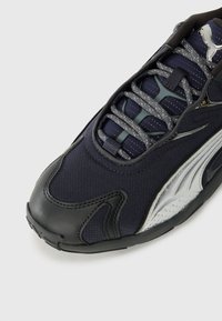 Marine sneakers med tekstureret stof, sølv detaljer og sort gummisål. Har mesh-overdel, forstærket tåhætte og reflekterende snørebånd.