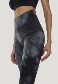 Højttaljede leggings i sort og gråt tie-dye mønster, lavet af strækstof med en glat tekstur og en tætsiddende pasform.