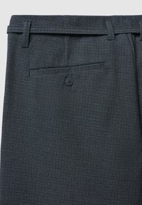 Dunkelgraue Hose mit einem dezenten, strukturierten Muster. Verfügt über Gürtelschlaufen in der Taille, eine einzelne Gesäßtasche und einen Knopfverschluss. Glatte Stoffoberfläche.