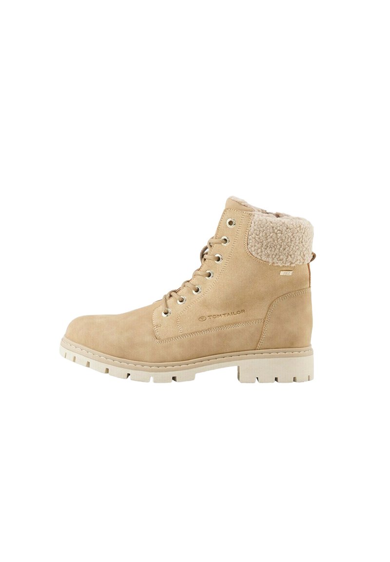 Lichtbeige enkellaars met een suede-achtige afwerking, nepbont kraag, veterfront en een witte rubberen zool met een robuust profiel.
