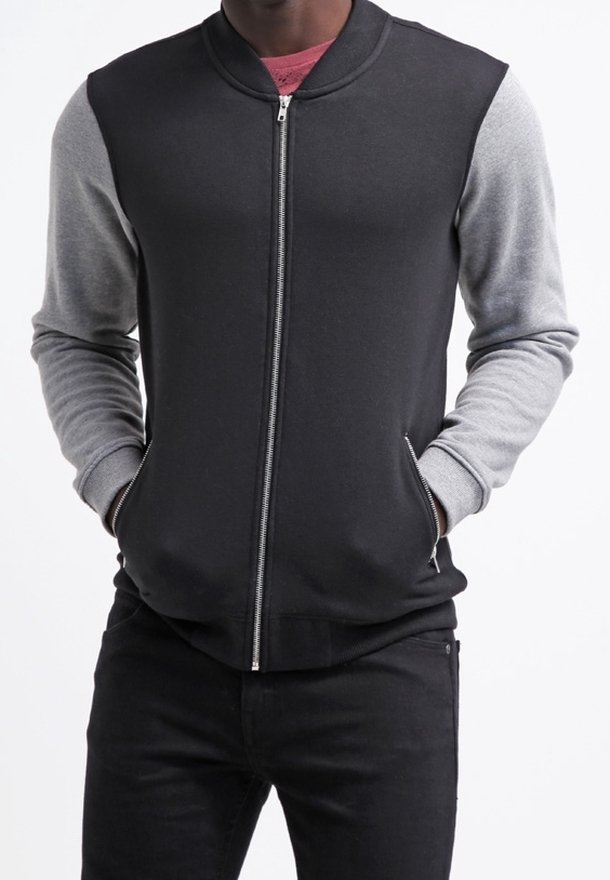 Černá bomber bunda na zip se šedými rukávy, žebrovaným límcem a manžetami, vyrobená z měkké látky. Má boční kapsy a hladký zip.