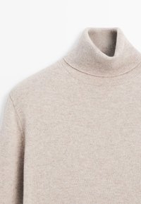 Beige gebreide turtleneck trui met lange mouwen, waarop details van het bovenlichaam en de kraag te zien zijn tegen een witte achtergrond.