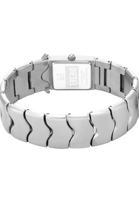 Edelstahlarmbanduhr mit rechteckigem Ziffernblatt, ausgestattet mit einem silbernen Armbanddesign mit wellenförmigen Akzenten und einem metallischen Finish.