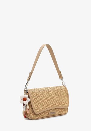 Väike ristkülikukujuline beež punutud käekott ühe õlarihmaga ja ühel küljel rippuva lillekujuline võtmehoidja aksessuaar.