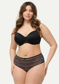 Reggiseno imbottito nero con bordi a onda e un fiocchetto al centro, abbinato a mutandine a vita alta a righe bianche e nere con dettagli rossi.