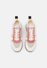 Baskets légères avec tige en mesh gris texturé, accents en suède rose, lacets blancs et languette noire. Semelle en caoutchouc pour une bonne adhérence.