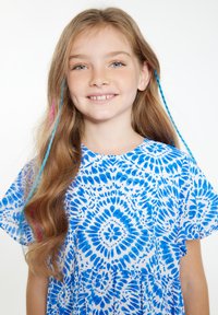 Mėlynai ir baltai raštuotas suknelė su trumpomis rankovėmis, su gėlių raštu. Ilgi rudi plaukai su mėlynais ir rožiniais sruogomis. Šypsosi.