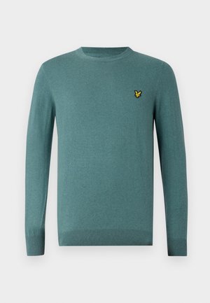 Maglione lavorato a maglia in verde teal smorzato, colletto rotondo, maniche lunghe, polsini e orlo a coste, presenta una piccola patch con logo giallo sul petto.
