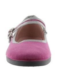 Zapato plano de tela rosa con punta redondeada, ribete gris y correa ajustable. La suela es negra, proporcionando un contraste con la parte superior vívida.