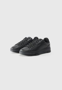 Black sneakers made of textured leather, featuring a rounded toe, lace-up front, and rubber sole with subtle logo detail on the side.