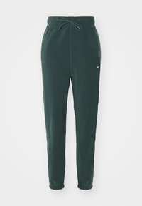 Gröna fleecebyxor med elastisk midja, justerbar dragsko och nederdelar med mudd. Har en liten vit logotyp på vänster lår.