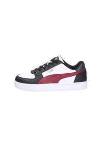 Zapatilla baja de Puma en negro, blanco y marrón con cierre de cordones y suela blanca, mostrada en perfil lateral.