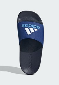 Chancla de color azul marino con una correa texturizada que presenta un logo azul elevado y tres rayas blancas. Suela de goma negra con el nombre de la marca en relieve.