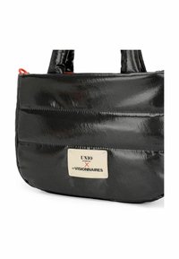 Schwarze, glänzende Handtasche mit rechteckiger Form; verfügt über gepolsterte Abschnitte, kurze Griffe und ein Markenlabel auf der Vorderseite.