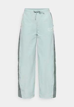 Heledad sinine tracksuit püksid elastse vöökoha, nööriga ja valgete triipudega külgedel. Esifraktsioonil on väike logo.