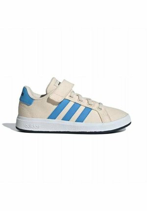 Sneaker Adidas beige avec des bandes bleues, fermeture à lacets à l'avant, une bride velcro au-dessus des lacets, semelle blanche et semelle extérieure noire.