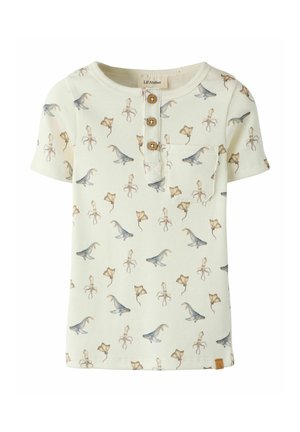 Kremowa krótka koszulka dziecięca z krótkim rękawem, prążkowana, z drewnianymi guzikami, małą kieszonką na piersi oraz wzorem dinozaura i płaszczki.