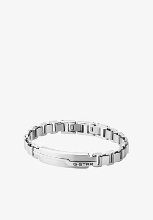 Sølv metalkæde armbånd med rektangulære led og en flad plade graveret med "G-STAR" på hvid baggrund.