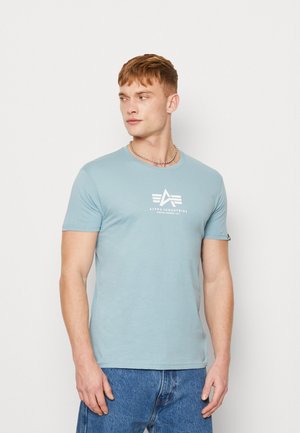 Himmelblaues Baumwoll-T-Shirt mit rundem Halsausschnitt, kurzen Ärmeln und einem weißen Logo-Graphic mit einem Adlersymbol auf der Vorderseite.