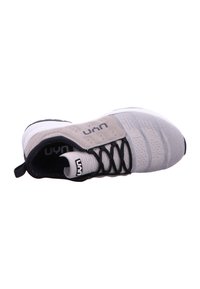 Light gray athletic shoe with a textured knit upper, black laces, and a padded tongue. Features a white sole and a branded heel tab.