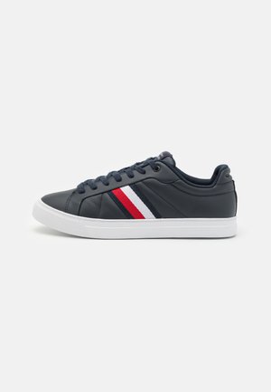 Sneakers in pelle blu navy con suola bianca, dotati di tre strisce di colore rosso, bianco e blu navy sul lato. Punta tonda e chiusura con lacci.