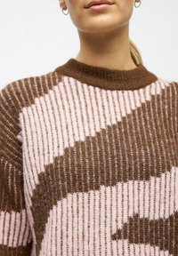 Pull en tricot avec un motif rayé marron et rose, doté d'une texture côtelée et d'un col rond. Matériau doux et chaud.