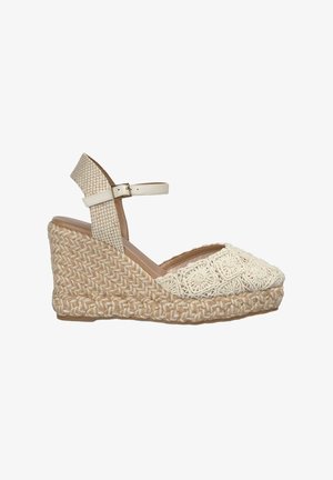 Wedge sandaal in beige en room, met een bovenwerk van textuurstof met een gebloemd haakpatroon en een gevlochten jute zool. Verstelbare enkelband.