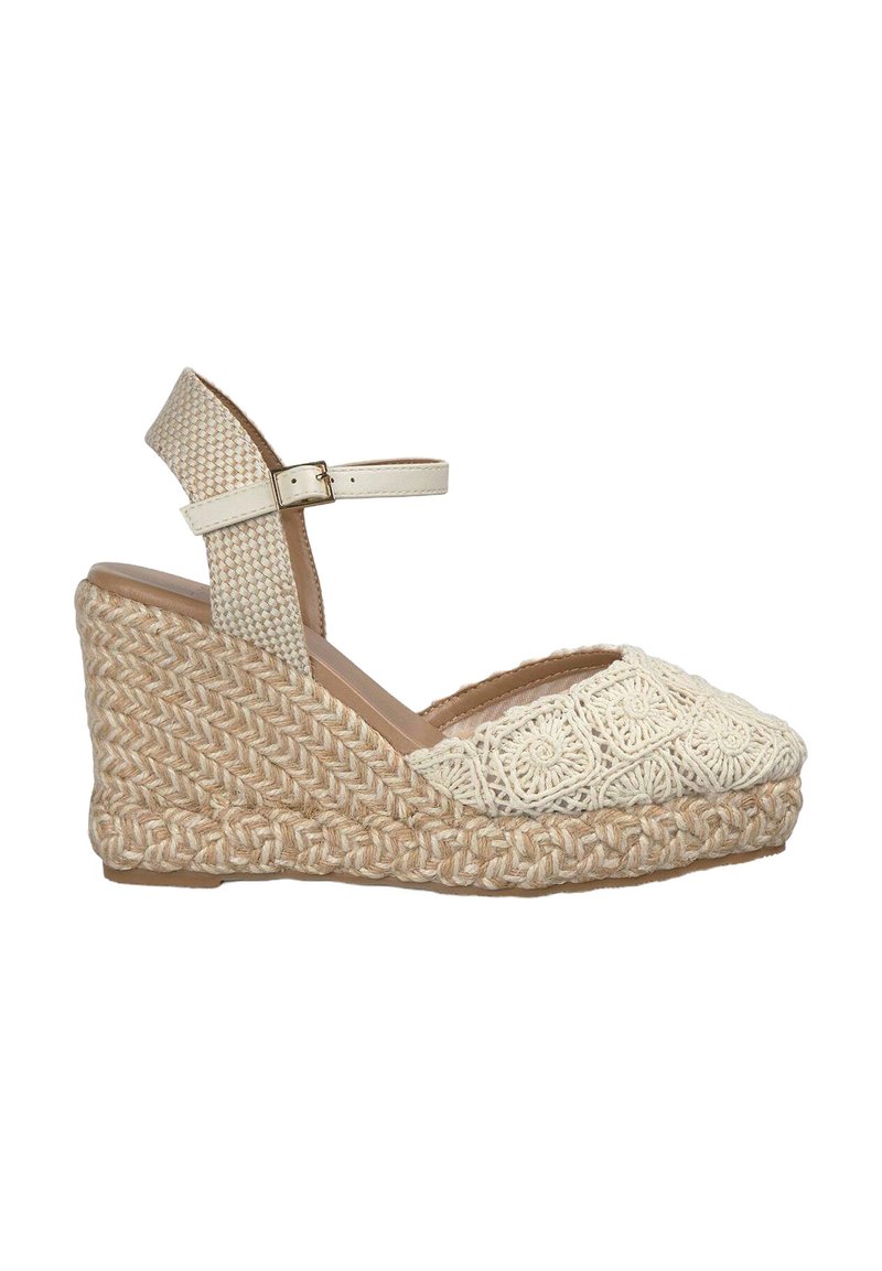 Wedge sandaal in beige en room, met een bovenwerk van textuurstof met een gebloemd haakpatroon en een gevlochten jute zool. Verstelbare enkelband.
