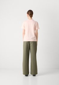 T-shirt in cotone rosa chiaro e pantaloni larghi verde oliva. Design semplice, maniche corte, i pantaloni presentano una vestibilità comoda e una sottile texture.