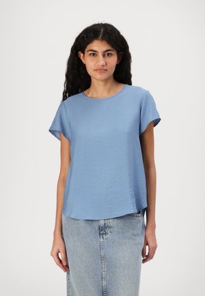 Blå, kortermet topp med rund hals og en lett teksturert overflate, kombinert med et lyst denimskjørt.