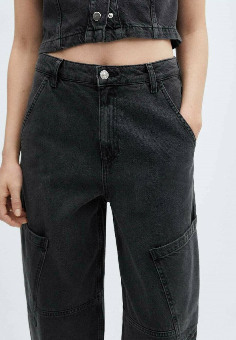 Pantaloni in denim neri a vita alta, con tasche laterali e dettagli di cucitura visibili. Il tessuto ha una texture liscia con una leggera lucentezza.