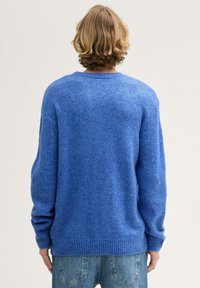Blaues, gestricktes Sweatshirt mit lockerer Passform, geripptem Saum und Bündchen, das eine weiche Textur und subtile Farbvariationen zeigt. Rückansicht.