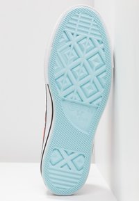 Semelle en caoutchouc bleu clair d'une sneaker Converse All Star avec des motifs de semelle géométriques et marquage de taille 4½.