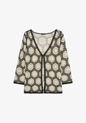 Schwarze und beige gehäkelte Strickjacke mit sechseckigen Blumenmustern, V-Ausschnitt und Dreiviertelärmeln.