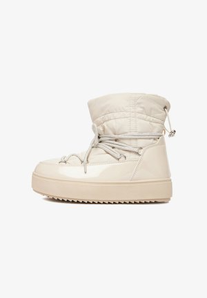 Botină de iarnă bej, cu partea superioară quilted, sistem de închidere cu șireturi frontal, cordon ajustabil în partea de sus și talpă groasă cu profil pentru aderență.