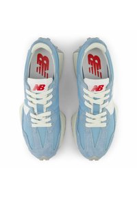 Ljusa blå sneakers med en blandning av släta och mockaliknande texturer, vita skosnören, krämfärgade detaljer och röd märkning på innersulorna.