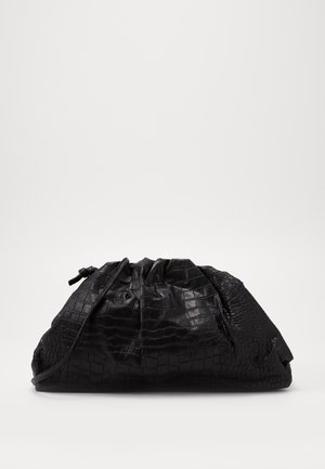 Bolso clutch de cuero negro sintético con textura de cocodrilo, cierre de cordón y forma holgada y recogida, reposando sobre una superficie blanca.