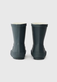 Botas de borracha pretas com um acabamento suave, de design curto e forro de pelúcia suave. Sola texturizada e acabamento decorativo ao longo da borda superior.