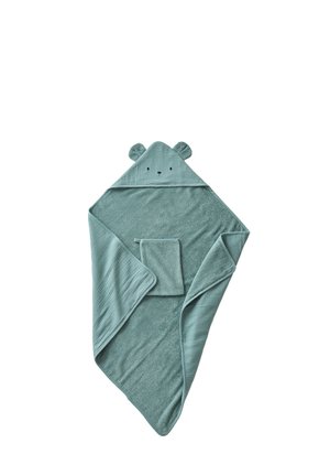 Weiches grünes Babyhandtuch mit Kapuze, Bärenohren und einem kleinen passenden Waschlappen daraufgelegt.