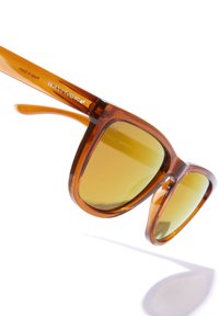 Brązowe okulary przeciwsłoneczne z acetatu z żółtymi soczewkami i wyrazistą, dużą oprawą. Posiadają charakterystyczne logo na zausznicy oraz eleganckie wykończenia.
