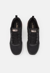 Schwarze Sportschuhe mit einem Obermaterial aus Mesh, das ein leichtes Design aufweist, weißer Sohle und Schnürsenkeln. Markenlogo auf der Zunge und den Seiten sichtbar.