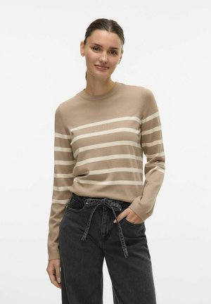 Beige striped sweater with long sleeves, featuring horizontal white stripes. Paired with black loose-fit jeans with a tied waist detail.