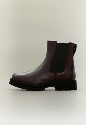 Mørkebrun læder Chelsea-støvle med sort elastisk sidepanel og tyk sort gummisål, vist fra venstre side på neutral baggrund.