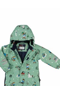Grön regnjacka för barn med huva, utsmyckad med lekfulla illustrationer av en snögubbe, en apa och en flicka i en snöig vinterscen.