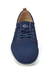Zapatos de malla azul marino con cordones, con puntera redonda, acentos beige en contraste y una parte superior texturizada. Suela blanca con un detalle sutil del logo.
