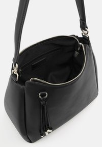 Schwarze Lederhandtasche mit silberner Hardware, Reißverschluss und Quasten-Detail. Verfügt über ein geräumiges Innenfach und eine glatte Textur.