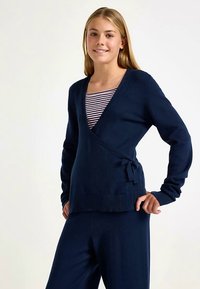 Marineblauer Wickelpullover aus weichem Strickmaterial, mit V-Ausschnitt, langen Ärmeln und einer Bindung in der Taille sowie einem gerippten Saum.