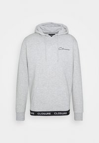 Grijze hoodie gemaakt van zachte stof met een voorzak, trekkoorden en het "CLOSURE" logo op de armband in zwart en wit.